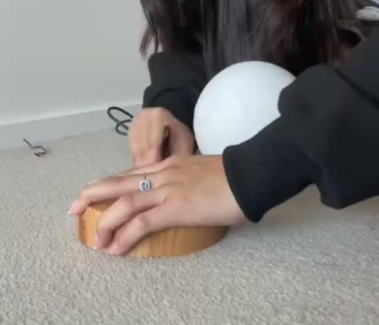 Installation de la lampe lune sur son socle magnétique en bois — aperçu de la taille réelle par rapport à la main