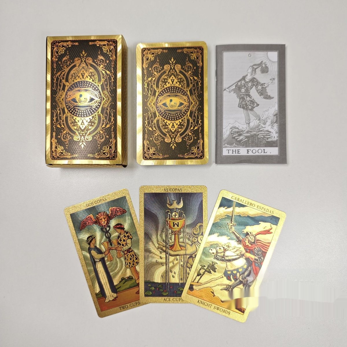 Tarot feuille d'or : étui doré, dos de cartes noir et or à l'œil mystique, cartes dorées et livret — cabinet de curiosités Curiosa