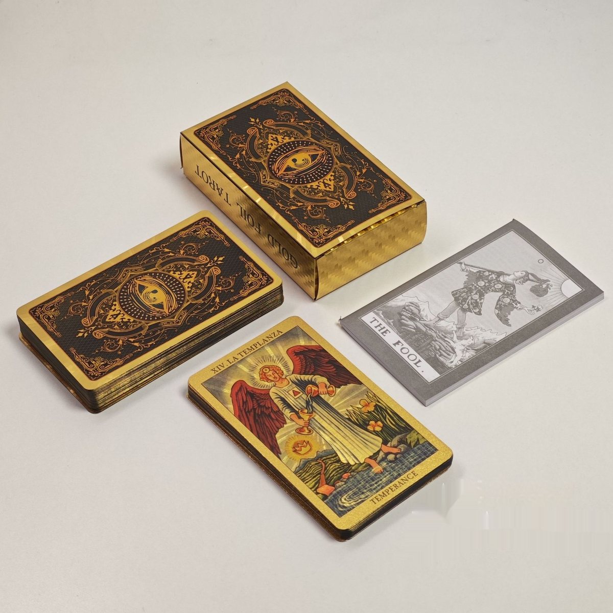 L'étui doré « Gold Foil Tarot », le paquet de cartes aux bords dorés et une carte La Tempérance en feuille d'or
